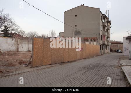 Un'immagine di un cantiere urbano a Edirne, Turchia, catturato nel 2012. La scena raffigura una struttura parzialmente completata su una strada deserta, racchiusa da barricate di legno, che trasmette un senso di sviluppo e urbanizzazione. Foto Stock