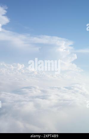 Una vista panoramica dall'alto delle nuvole che mostra chiare e soffici nuvole contro un sereno cielo blu. Suscita sentimenti di tranquillità, calma e pace con un senso di essere al di sopra del mondo. Foto Stock