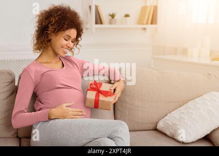 Felice africana incinta-donna americana con confezione regalo Foto Stock