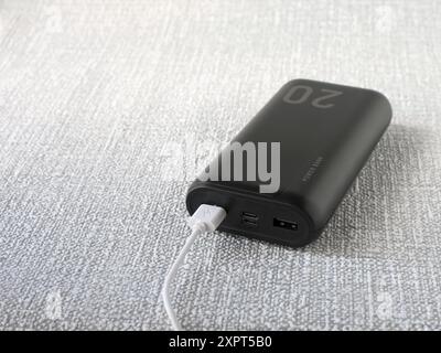 Immagine di un potente power Bank portatile con una capacità di 20.000 milliampere con un cavo collegato. Foto Stock