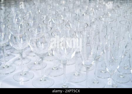 Primo piano di molti bicchieri da vino vuoti su un tavolo. Piatti del ristorante per il ricevimento degli ospiti e una festa alcolica. C'era molto champagne pulito Foto Stock