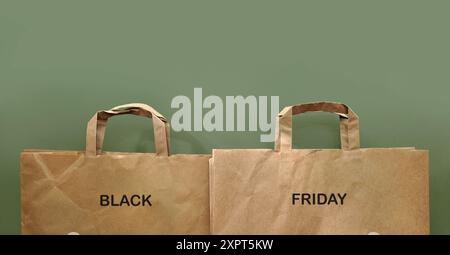 Sacchetti per la spesa in carta su sfondo monocromatico. Sostenibilità. Consumo. Shopping natalizio. Vendite. Parole scritte "Black Friday" Foto Stock