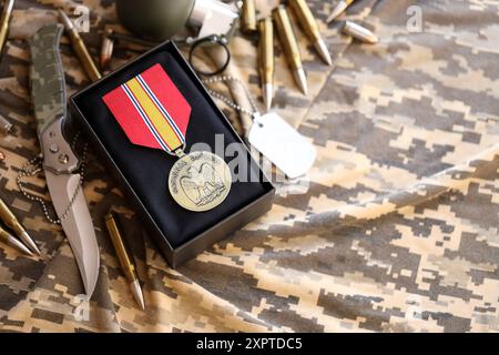 KIEV, UCRAINA - 10 LUGLIO 2024 Medaglia del servizio generale di difesa Nazionale. Medaglia di premio militare degli Stati Uniti con nastro e spilla. Primo piano di oggetti di scena fatti a mano in carta Foto Stock