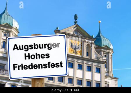 7 agosto 2024: Immagine simbolica di una festa pubblica ad Augusta, in Baviera, l'8 agosto. Il Festival dell'alta Pace di Augusta. Cartello di fronte alla torre della chiesa con l'iscrizione: Augsburg High Peace Festival. FOTOMONTAGGIO *** Symbolbild Feiertag im bayerischen Augusta mattina 8 agosto. DAS Augsburger Hohe Friedensfest. Schild vor Kirchturm mit Aufschrift: Augsburger Hohes Friedensfest. FOTOMONTAGE Foto Stock