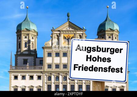 7 agosto 2024: Immagine simbolica di una festa pubblica ad Augusta, in Baviera, l'8 agosto. Il Festival dell'alta Pace di Augusta. Cartello di fronte alla torre della chiesa con l'iscrizione: Augsburg High Peace Festival. FOTOMONTAGGIO *** Symbolbild Feiertag im bayerischen Augusta mattina 8 agosto. DAS Augsburger Hohe Friedensfest. Schild vor Kirchturm mit Aufschrift: Augsburger Hohes Friedensfest. FOTOMONTAGE Foto Stock