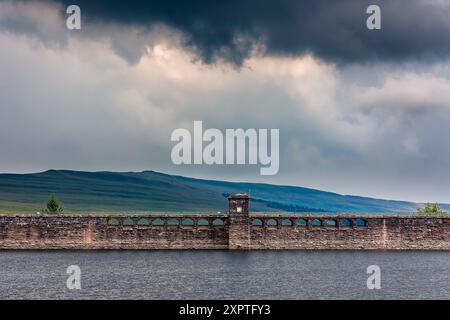 Parete diga di un vecchio bacino idrico in un paesaggio rurale in una giornata tempestosa (Grwyne Fawr) Foto Stock