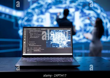 Concentratevi sulla tecnologia di computing cognitivo basata sull'intelligenza artificiale utilizzata dai colleghi in background sfocato. Primo piano del notebook utilizzato dal team di programmatori per eseguire l'estrazione dei dati con algoritmi di autoapprendimento Foto Stock
