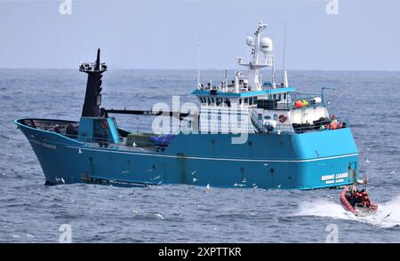 Una squadra di imbarco delle forze dell'ordine Cutter Kimball (WMSL 756) della guardia costiera si rivolge al capo F/V Bering per condurre un imbarco di risorse marine vive mentre l'equipaggio di Kimball pattuglia il Mare di Bering, il 25 maggio 2024. L’equipaggio di Kimball ha assicurato che le navi da pesca nel Mare di Bering rispettassero tutte le leggi federali in materia di conservazione della pesca e le norme di sicurezza attraverso il completamento di venti imbarchi per risorse marine viventi durante il loro pattugliamento di 122 giorni in tutta la regione. Foto della Guardia Costiera degli Stati Uniti di Ethan Isberner, sottufficiale di prima classe. Foto Stock