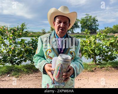 Jhon Smith Noriega posa per un ritratto accanto al canale superiore a Laguna del Nainari nella città di Obregón, Sonora, Messico, il 14 luglio 2024. Jhon indossa un costume del gruppo musicale popolare o regionale la banda chiamato lLaberinto mentre chiede sostegno finanziario con una barca con l'immagine della Vergine di Guadalupe per "mi Casa Albergue" (foto di Luis Gutiérrerez / Norte foto) Jhon Smith Noriega posa para un retrato junto al Canal alto en la Laguna del Nainari en ciudad Obregón Sonora México el 14 julio 2024. Jhon viste de traje de la agrupación de músical Popular o Regional de la banda Foto Stock