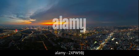 Una vista aerea della città di ho chi Minh al tramonto, un cielo vivace e colorato, il grattacielo Landmark 81 illuminato, il fiume Saigon riflesso nelle luci della città Foto Stock