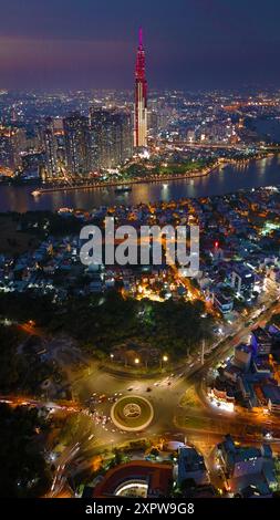 Una vista aerea della città di ho chi Minh al tramonto, un cielo vivace e colorato, il grattacielo Landmark 81 illuminato, il fiume Saigon riflesso nelle luci della città Foto Stock