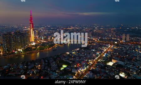 Una vista aerea della città di ho chi Minh al tramonto, un cielo vivace e colorato, il grattacielo Landmark 81 illuminato, il fiume Saigon riflesso nelle luci della città Foto Stock