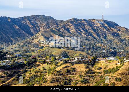L'insegna di Hollywood, vista da Mulholland Drive, con case su una cresta sotto Griffith Park, Los Angeles, California, USA, vista aerea Foto Stock