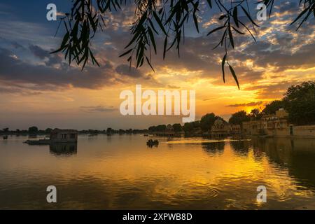 Spettacolare tramonto sul lago Gadisar, Jaisalmer, Rajasthan, India. Sole e nuvole colorate nel cielo con vista sul lago Gadisar. Connessione WIT Foto Stock