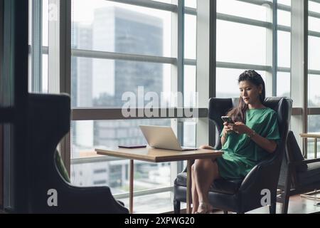 Donna d'affari asiatica hot desking e occupata con il lavoro Foto Stock