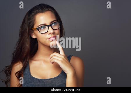 Pensiero, donna e occhiali per la salute in studio di cura degli occhi, opinione della lente e cornice di prescrizione. Ragazza, pensieri e occhiali firmati per Foto Stock