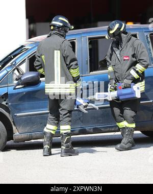 i vigili del fuoco che utilizzano potenti cesoie idrauliche e spanditori aprono la porta dell'auto dopo l'incidente stradale per liberare le vittime dal veicolo Foto Stock