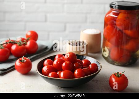 Gustosi pomodori sottaceto, verdure fresche e spezie su un tavolo grigio chiaro Foto Stock