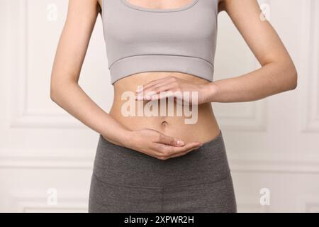 Digestione sana. Donna che tiene qualcosa vicino alla pancia dentro, primo piano Foto Stock