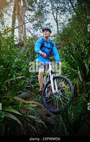 Uomo, fitness e foresta per avventure ciclistiche all'aperto, pensare e pianificare sport estremi. Uomo, atleta e allenamento in natura per Foto Stock