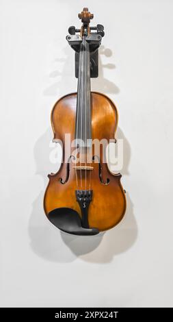 Violino, strumento musicale appeso su una parete grigia. Classico, Copia spazio Foto Stock