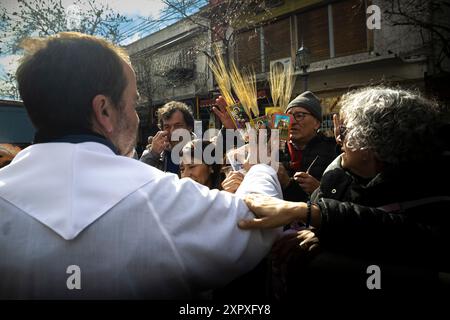 Buenos Aires, Argentina. 7 agosto 2024. Uno dei sacerdoti che cammina tra i fedeli fuori dal santuario benedice le sacre carte del santo. Ogni 7 agosto si celebra San Cayetano, santo del pane e del lavoro. Milioni di devoti si riuniscono nei diversi santuari di tutto il paese per chiedere la sua intercessione e ringraziarlo per i favori ricevuti. Le code iniziano giorni prima della celebrazione e una volta aperte le porte, le persone aspettano fino a 7 ore per entrare. Credito: SOPA Images Limited/Alamy Live News Foto Stock