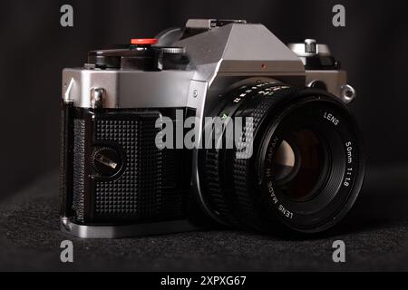 Primo piano di una videocamera vintage su sfondo nero, che mette in risalto il suo design classico e i dettagli intricati. Eleganza senza tempo. Foto Stock