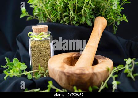 Origanum selvatico, marjoram selvatico (Origanum vulgare), origano fresco e strofinato in vaso, con mortaio Foto Stock