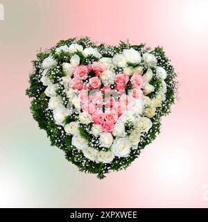 Cuore fatto di rose rosa e bianche per un servizio funebre, composizione Foto Stock