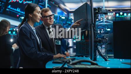 Diversi operatori di sesso femminile e maschile che analizzano dati finanziari in tempo reale e report sullo stato del mercato finanziario. I professionisti di Borsa discutono di opzioni di acquisto e vendita per diverse obbligazioni Foto Stock