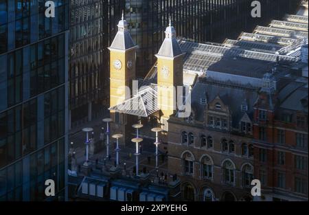 Luce che cade sulle torri d'ingresso della stazione di Liverpool Street, City of London, London, Inghilterra Foto Stock