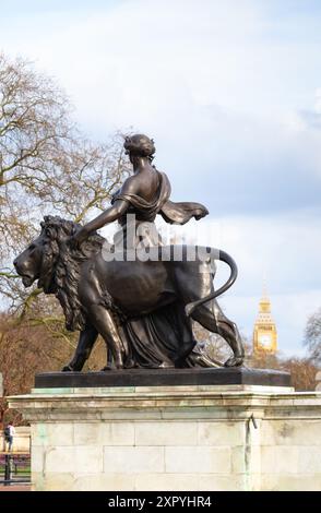 Figura di bronzo della Pace sostenuta da un leone di bronzo, con il Big Ben sullo sfondo, Victoria Memorial, The Mall, Londra, Inghilterra Foto Stock