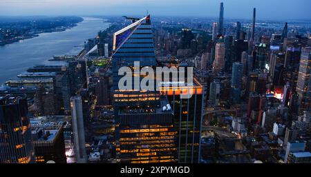 Foto notturna in elicottero dello skyline di Manhattan, bloccato su 30 Hudson Yards Skyscraper con una piattaforma di osservazione esterna. Folla di persone che si godono la vista serale da una piattaforma panoramica Foto Stock