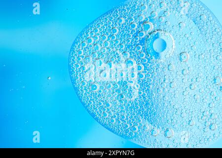 Immagine astratta con forma liquida blu di forma organica con numerose bolle sospese su sfondo a gradiente di luce. toni e floati freddi Foto Stock