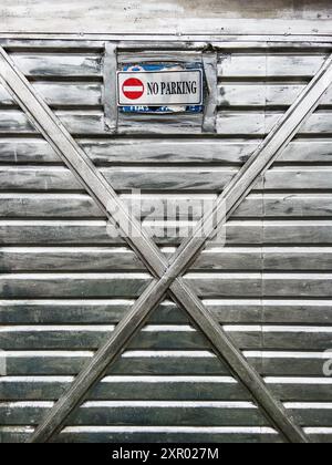 Nessun segnale di parcheggio sulla vecchia porta metallica del garage, immagine verticale Foto Stock