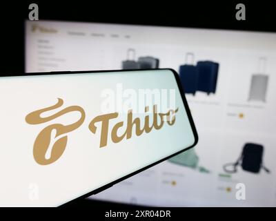 Telefono cellulare con logo della società tedesca Tchibo GmbH di fronte al sito web aziendale. Mettere a fuoco la parte centrale sinistra del display del telefono. Foto Stock