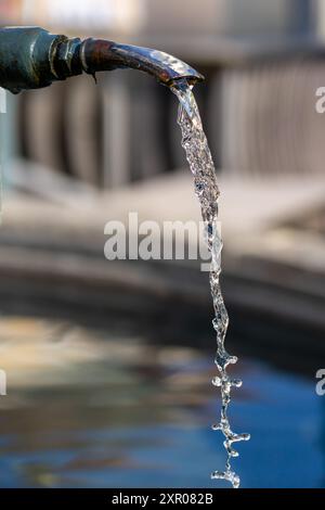 L'acqua potabile scorre dal rubinetto di una fontana della città. Foto Stock