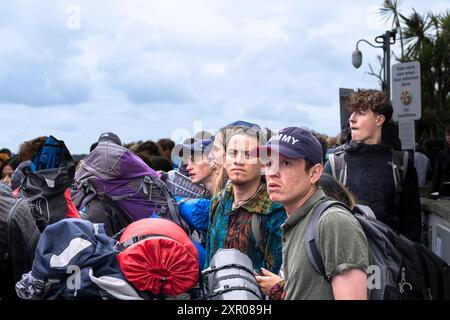 I giovani che arrivano alla stazione ferroviaria di Newquay aspettano gli autobus per portarli al festival Boardmasters di Newquay, in Cornovaglia, nel Regno Unito. Foto Stock