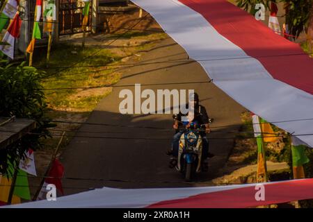 8 agosto 2024, West Bandung Regency, Giava Occidentale, Indonesia: Un passaggio motociclistico sotto un panno rosso e bianco lungo 240 metri per accogliere il 79° anniversario dell'indipendenza della Repubblica di Indonesia nel villaggio di Pasirpogor, West Bandung Regency, Giava Occidentale. (Credit Image: © Dimas Rachmatsyah/ZUMA Press Wire) SOLO PER USO EDITORIALE! Non per USO commerciale! Foto Stock