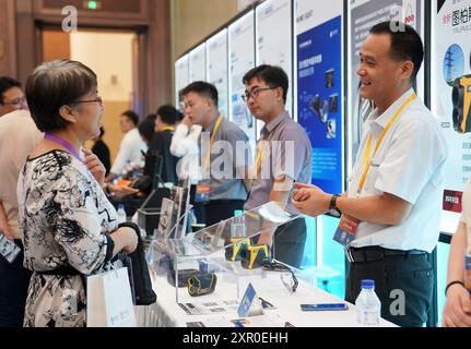 Shanghai. 8 agosto 2024. Un espositore (R) presenta i prodotti a un acquirente durante un incontro pre-expo tra domanda e offerta per l'Intelligent Industry & Information Technology Exhibition area e l'Automobile Exhibition area della 7a China International Import Expo (CIIE) presso il National Exhibition and Convention Center (Shanghai) nella parte orientale di Shanghai, 8 agosto 2024. Il 7° CIIE si terrà dal 5 al 10 novembre. Crediti: Chen Haoming/Xinhua/Alamy Live News Foto Stock