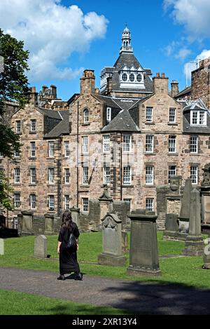 Donna vestita di nero che cammina nel Greyfriars Kirkyard nella città vecchia di Edimburgo. Foto Stock