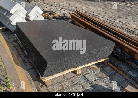 Cuscinetto pneumatico in un cantiere di binari del tram in una strada europea. Realizzati con gomma riciclata di vecchi pneumatici. Foto Stock