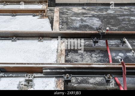 Cuscinetto pneumatico in un cantiere di binari del tram in una strada europea. Realizzati con gomma riciclata di vecchi pneumatici. Foto Stock