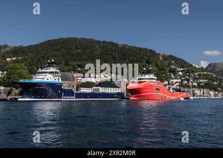 Nave offshore PSV North Pomor e nave AHTS Aurora Saltfjord presso la banchina Festningskaien nel porto di Bergen, Norvegia. Gli antichi Bergenhus e Haakonshallen Foto Stock