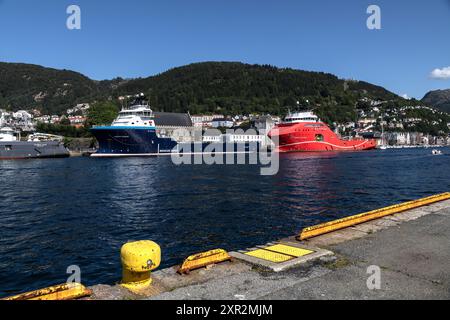 Nave offshore PSV North Pomor e nave AHTS Aurora Saltfjord presso la banchina Festningskaien nel porto di Bergen, Norvegia. Gli antichi Bergenhus e Haakonshallen Foto Stock