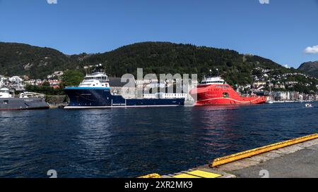 Nave offshore PSV North Pomor e nave AHTS Aurora Saltfjord presso la banchina Festningskaien nel porto di Bergen, Norvegia. Gli antichi Bergenhus e Haakonshallen Foto Stock