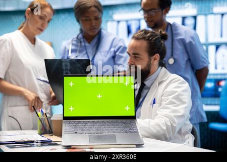 Diversi team di specialisti che esaminano le scansioni di test radiografici con schermo isolato in una riunione, esaminando i risultati dei raggi X in un centro di trattamento. Personale professionale che garantisce la prevenzione delle malattie. Foto Stock