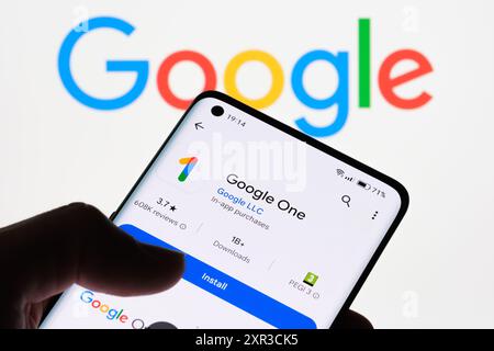 Primo piano dello schermo di uno smartphone con l'app Google One sullo sfondo con il logo Google, che mostra il collegamento tra Google One e Google Stafford Foto Stock