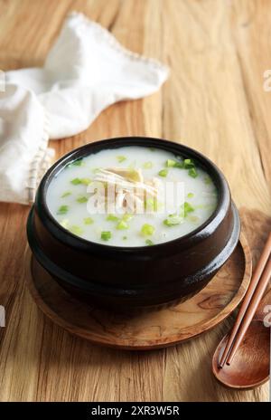 Dakjuk, porridge coreano di pollo al riso con cipolla verde tritata. Servita su Ttukbaegi, Korean Stone Bowl Foto Stock