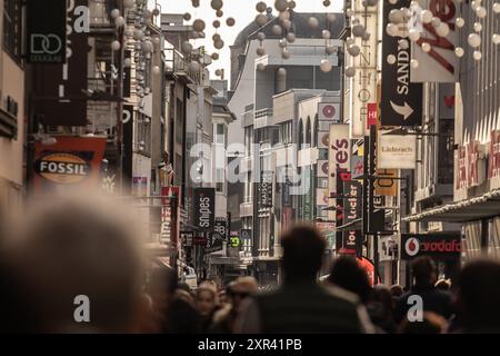 Foto di hohestrasse con negozi e negozi in un sabato pomeriggio con una folla di persone che fanno shopping a Colonia, Germania. Hohe Straße è una via dello shopping Foto Stock